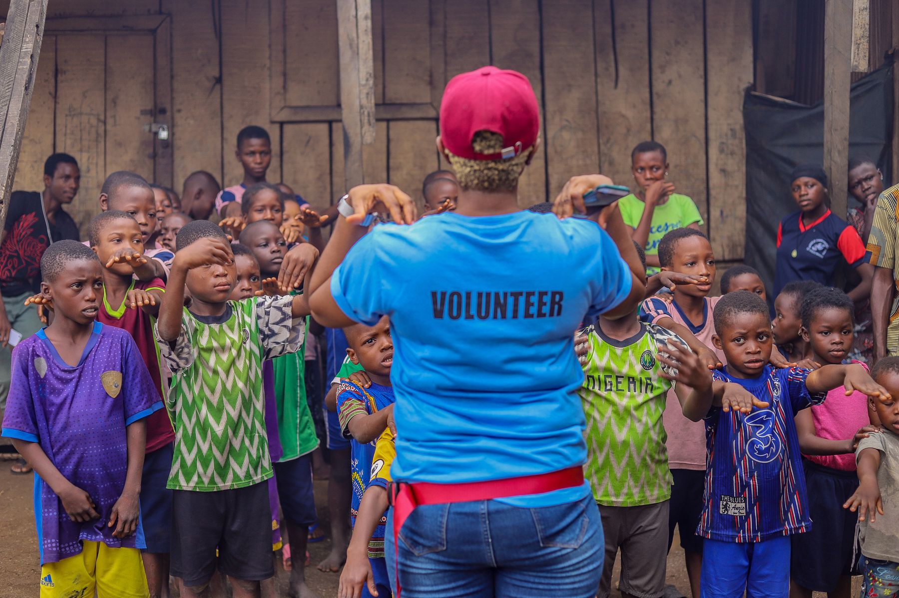 A volunteer guiding children in a community activity